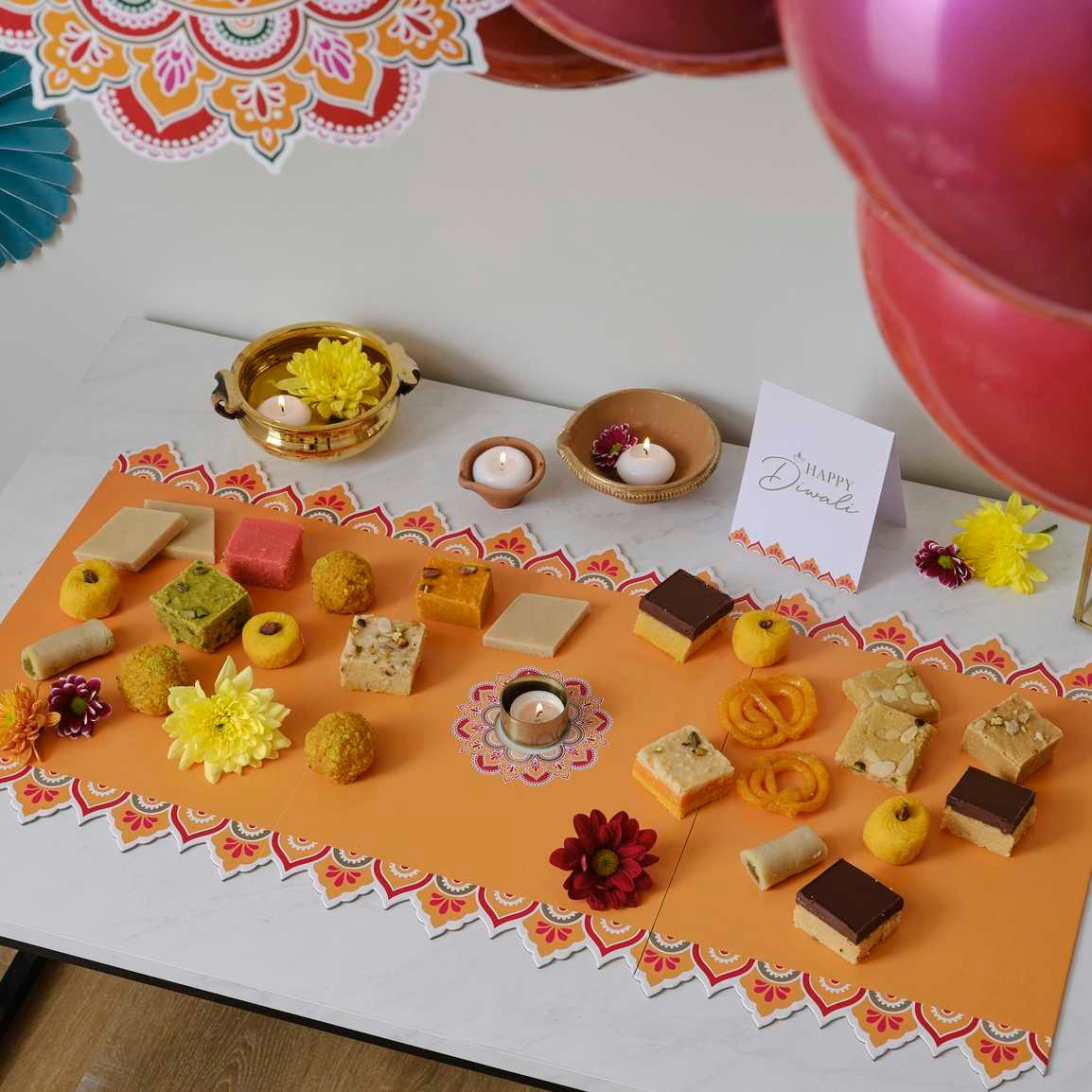 Table decoration with ornaments 1 x fold out Diwali grazing board measuring 394mm (H) x 800mm (W) and 1 x tent card measuring 280mm (H) x 110m (W).
